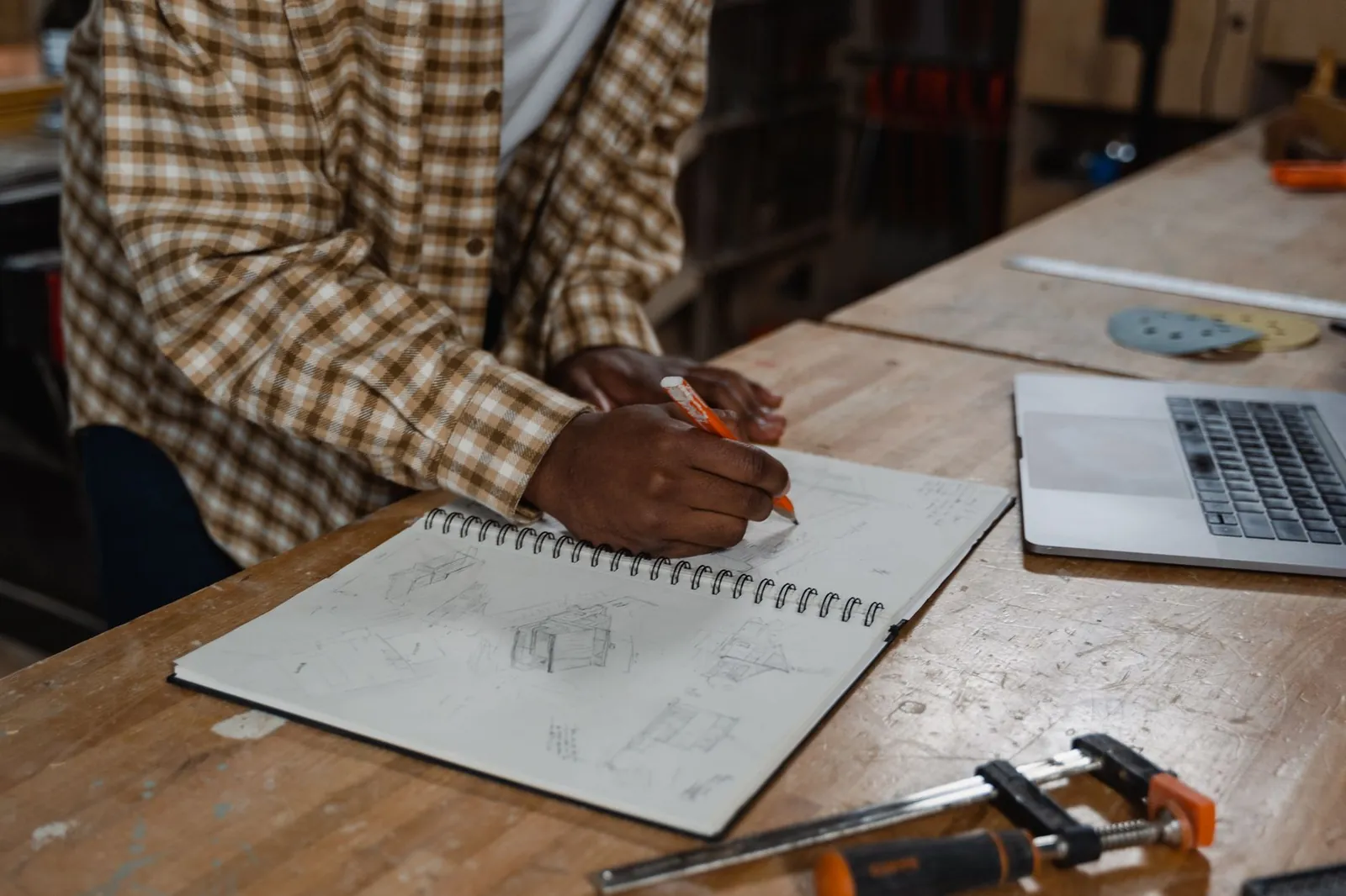 A notebook with game design sketches beside a laptop